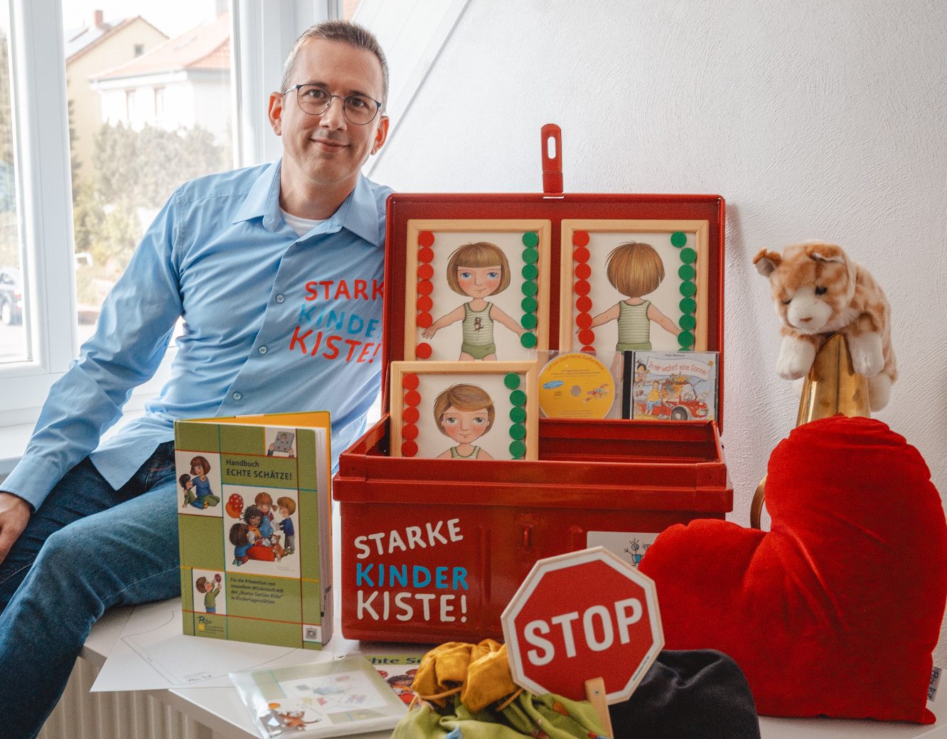 David M. Heltzel mit Materialien der Starke Kinder Kiste zur Prävention sexualisierter Gewalt in Kitas